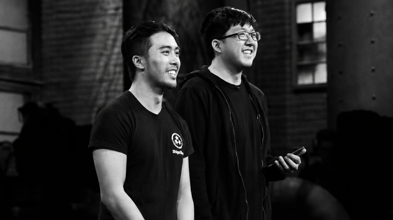 Two Victoria founders on stage, smiling as the crowd reacts
